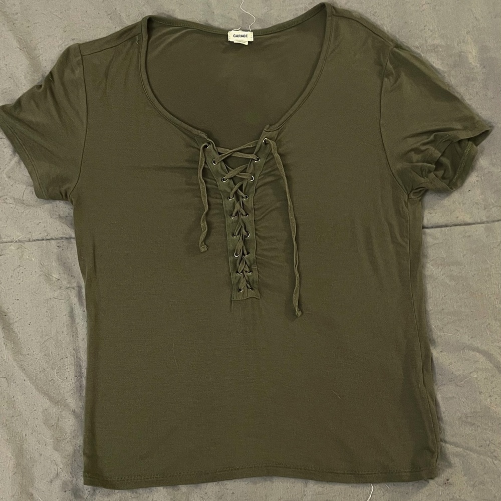 Dark green shirt with tie up front by garage.